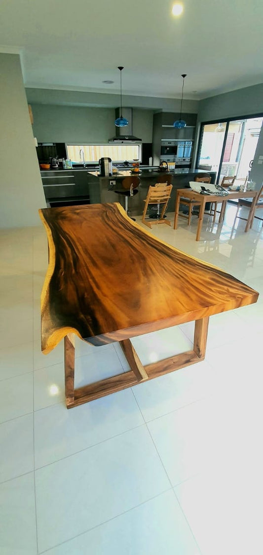 Handcrafted Sheesham wood dining table with a live edge design, showcasing natural wood grain and solid construction.